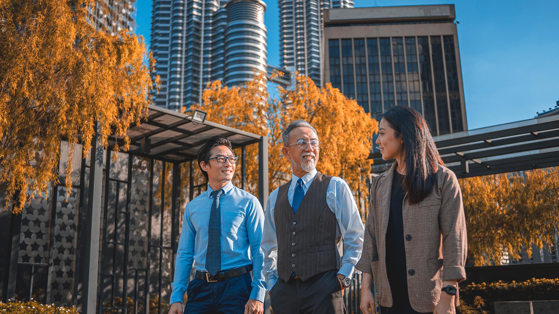 Three financial advisors walking together in the park