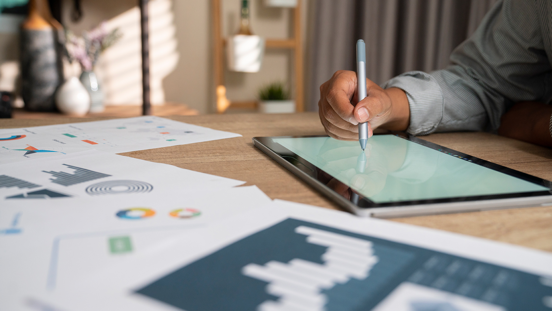 Woman sitting at a table and writing on their tablet