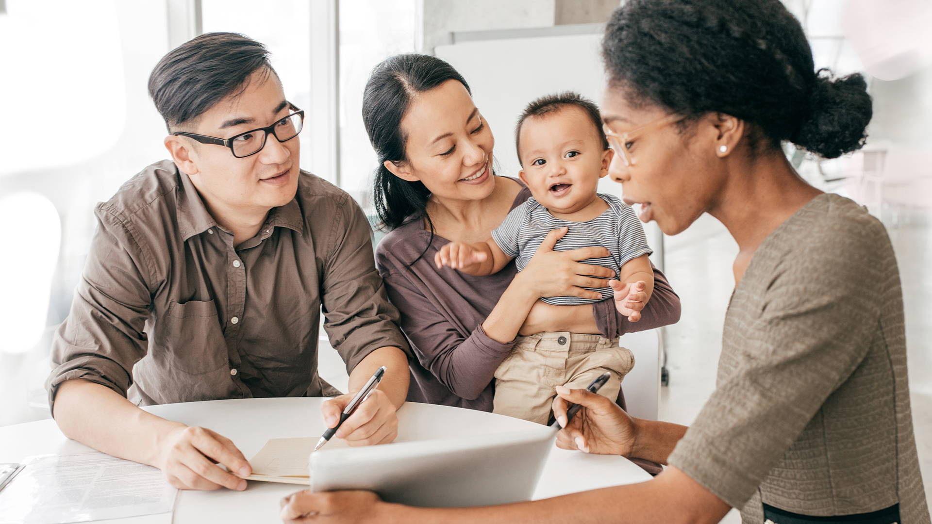 Young family meeting with their female financial advisor