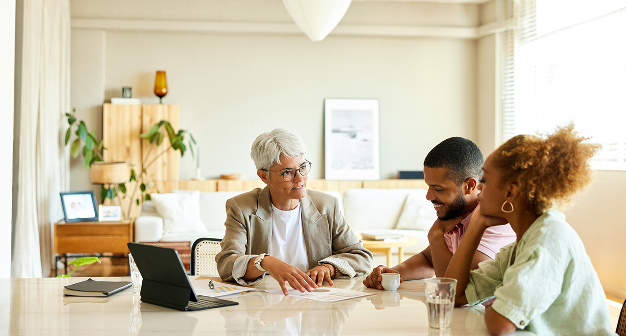 Female financial planner meeting with a married couple in their home