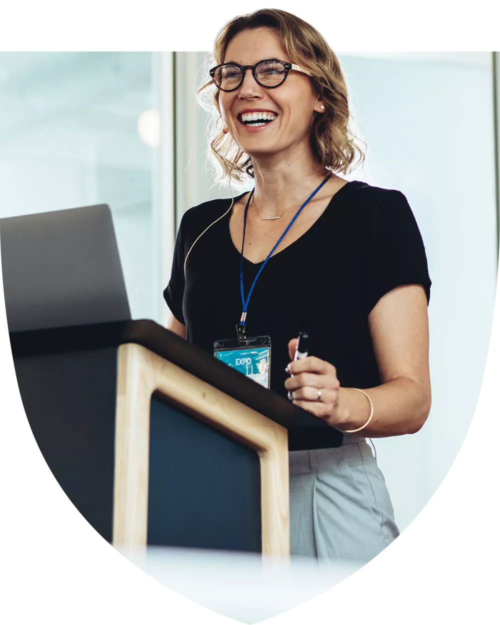 Happy businesswoman standing at the podium presenting to crowd