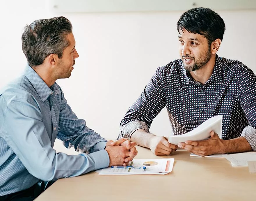 Two men talking at a table