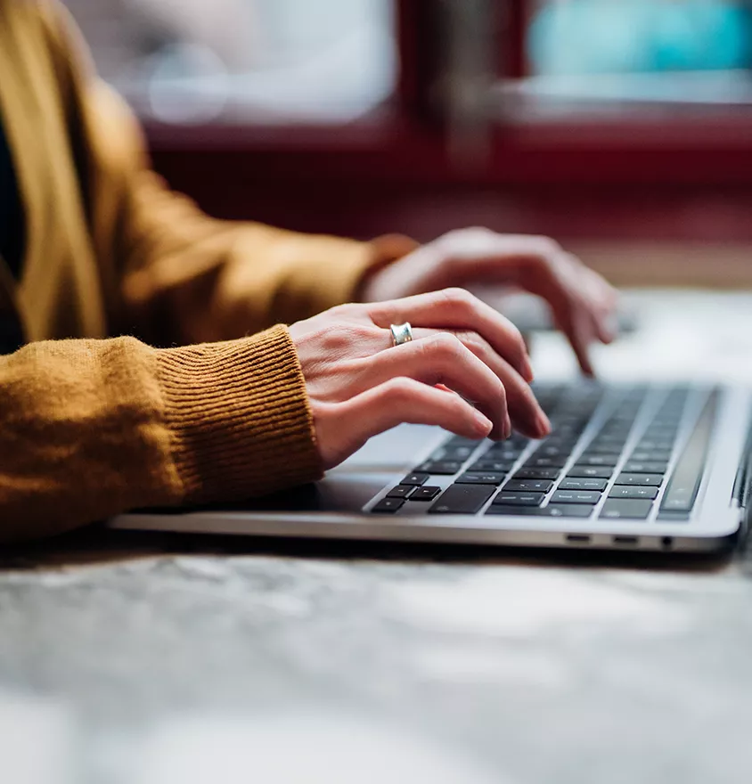 Close up of a woman's hands on a laptop