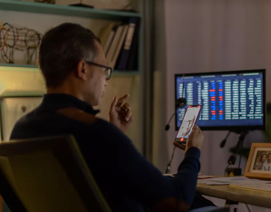 A man looking at his phone and computer 