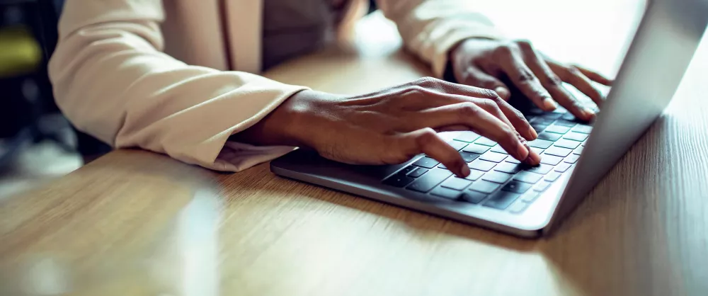 Close up of hands working on a tablet 