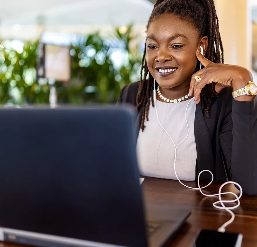 Woman looking at a laptop with headphones in