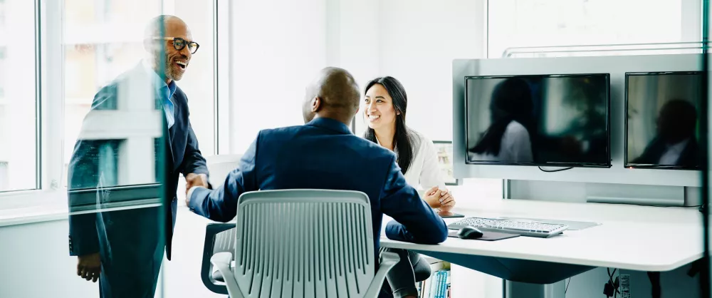 Three people talking in an office 