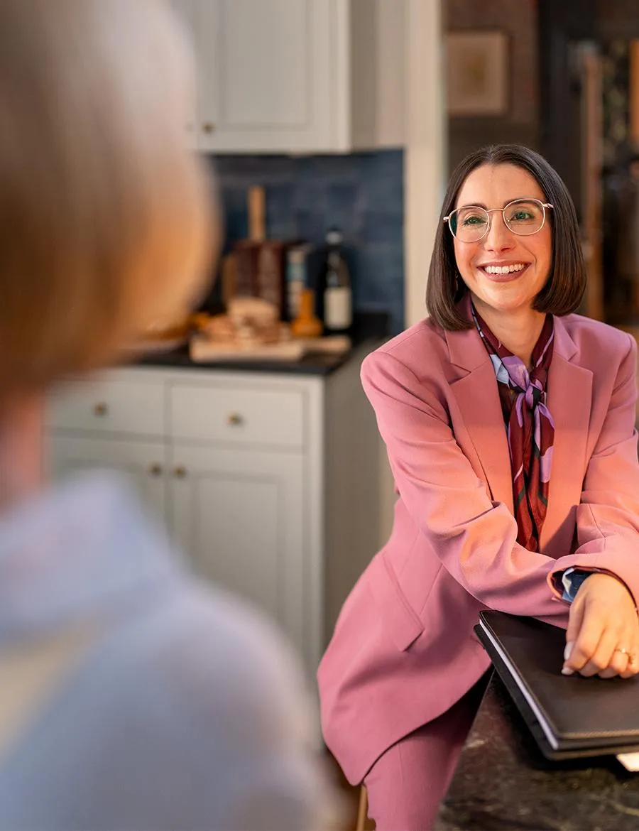 Female financial advisor smiling wearing a purple suit