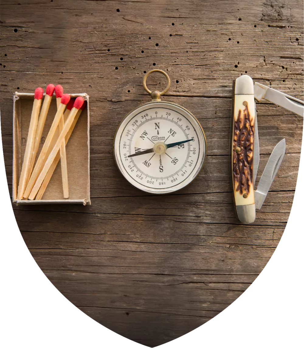 Matches, compass, and pocket knife on a table