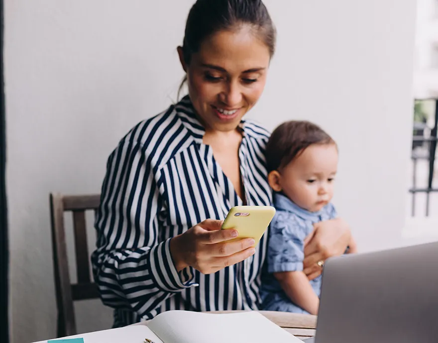 Woman holding her baby while on the phone