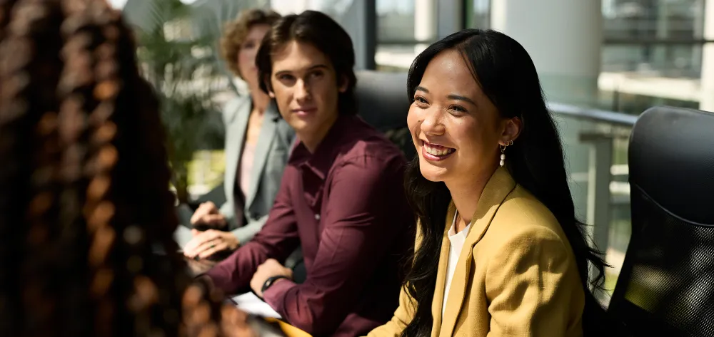 Asian female in her mid 30's smiling in a work meeting