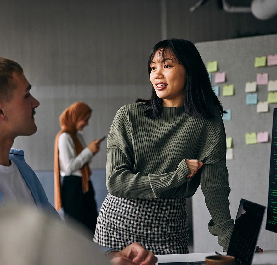 Young female professional talking with her colleague in the office