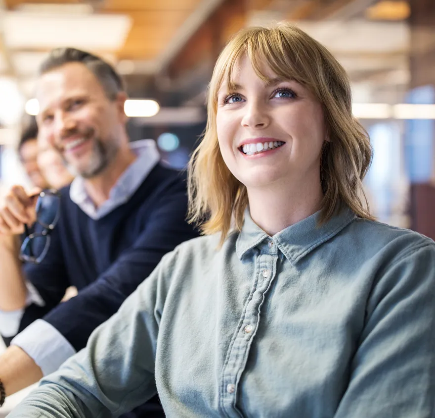 Team at work smiling while attending a meeting
