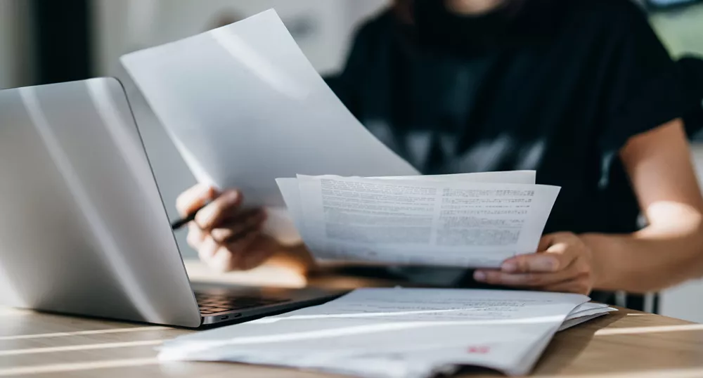 Woman sifting through papers at her desk