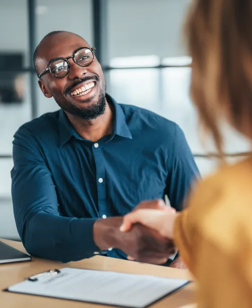 Professional man and women shaking hands and smiling in the office