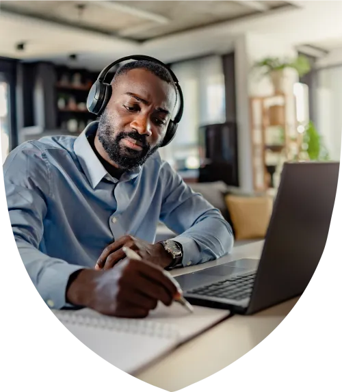 Man with headphones on studying at his desk