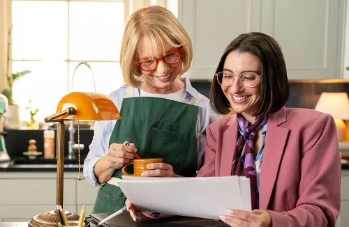 Elderly woman sitting in her kitchen with an advisor