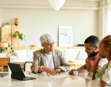 Female financial planner meeting with a married couple in their home