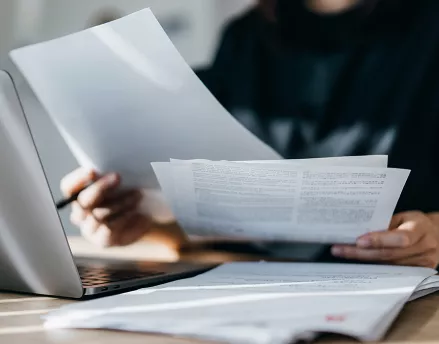 Woman sifting through papers at her desk