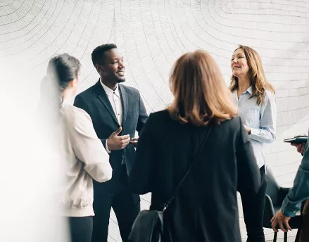 Diverse group of colleagues speaking together in a circle 